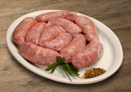 Fresh raw sausage on the old wooden background. sausage herbs.の写真素材