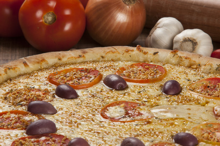 Traditional italian pizza with ingredients on wooden.の写真素材
