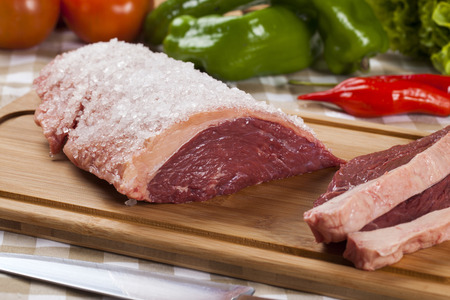 raw steak on wooden board with vegetablesの写真素材