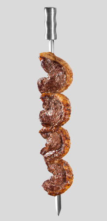 Spit roast sirloin in white background. Picanha barbecue.の写真素材