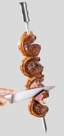 Spit roast sirloin in white background. Picanha barbecue.の写真素材