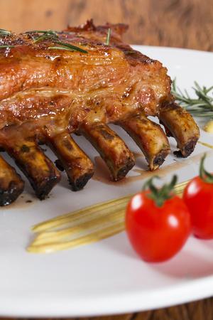Tasty grilled ribs on board with vegetablesの写真素材