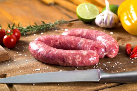 Fresh raw sausage on the old wooden background. Sausage toscanaの写真素材