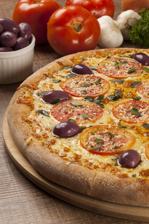Traditional italian pizza with ingredients on wooden.の写真素材