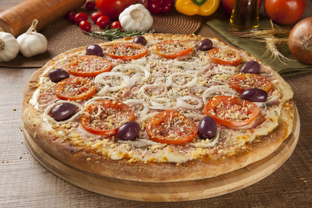 Traditional italian pizza with ingredients on wooden.の写真素材