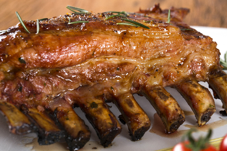 Tasty grilled ribs on board with vegetablesの写真素材