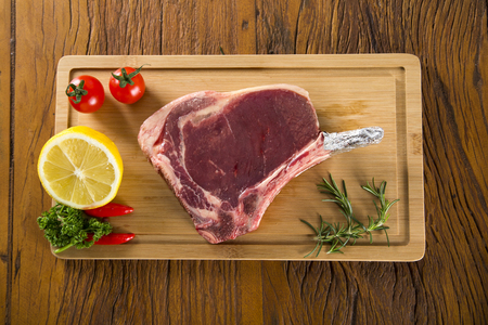 Prime ribs raw on the board with vegetablesの写真素材