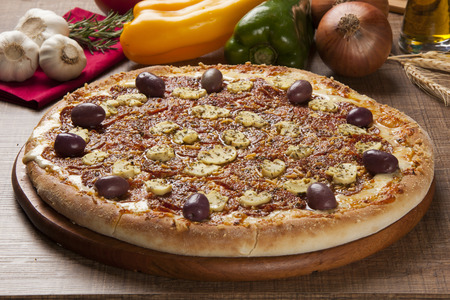 Traditional italian pizza with ingredients on wooden.の写真素材