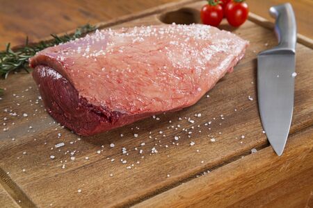 raw steak on wooden board with vegetablesの写真素材