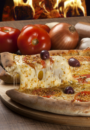 Traditional italian pizza with ingredients on wooden.の写真素材