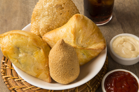 Mixed Brazilian deep fried chicken snack,, esfihas and pastry with juice and soda - popular at local...