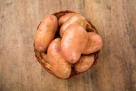 Fresh potatoes on rustic wooden background. Fresh vegetable.の写真素材