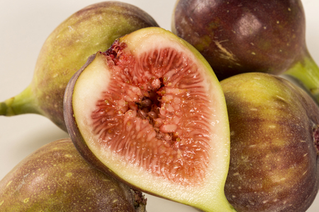 A couple of figs in a pot over a wooden table. Fresh fruit.の写真素材