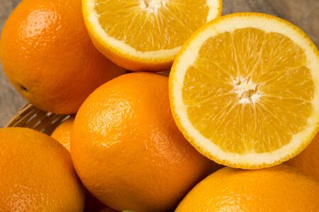 Close up of some oranges in a basket over a wooden surface. Fresh fruit.の写真素材