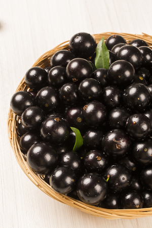 Berry Jaboticaba in bowl on wooden table. Brazilian Fruit.の写真素材