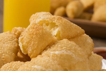 Pastel, a Brazilian snack, with a bar in the background. Cheese pastry on wooden background.の写真素材