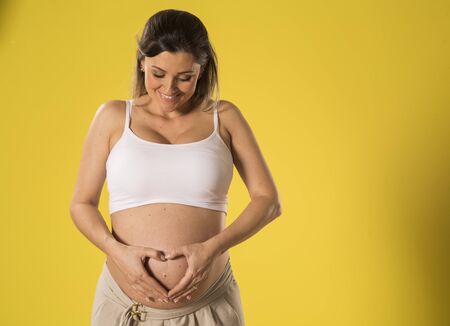 Pregnant woman making heart with her hands.の写真素材