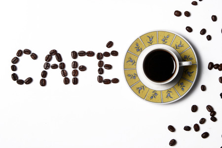 Coffee in the cup with coffee beans around.の写真素材