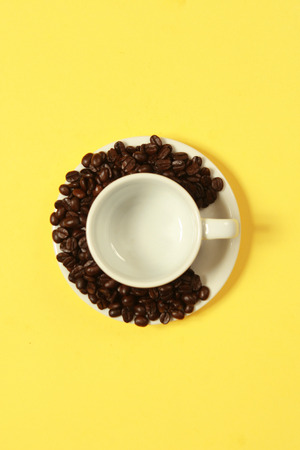 Coffee beans wrapped in a cup on a yellow background.の写真素材