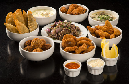 Mixed brazilian snacks, including pastries, fried chicken, salads, soups, fries, kibe .の写真素材