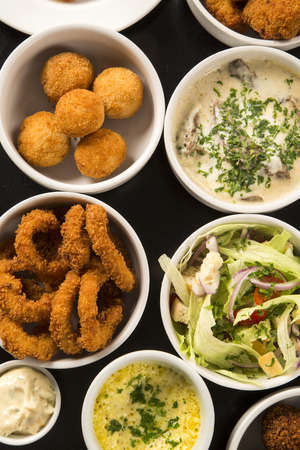 Mixed brazilian snacks, including pastries, fried chicken, salads, soups, fries, kibe .の写真素材