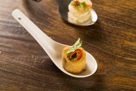 Polenta cups with shredded ragu and cabbage chips in a spoon. Taste gastronomy finger foodの写真素材