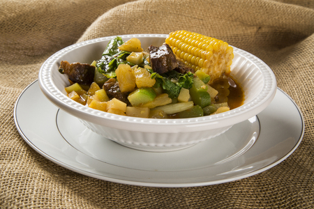 South American cuisine: Puchero soup with chickpeas close-up in a pot on the table.の写真素材