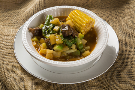 South American cuisine: Puchero soup with chickpeas close-up in a pot on the table.の写真素材