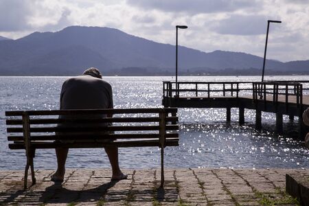 Man sitting looking at the sea. Sao francisco do sul. Santa Catarina. July 2017のeditorial素材