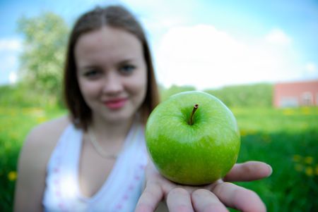 Girl offer green appleの写真素材