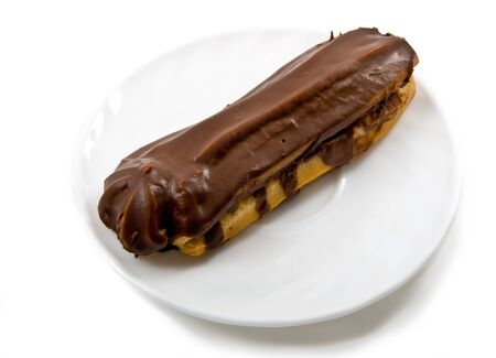 chocolate cake (eclair) on plate isolated over whiteの写真素材