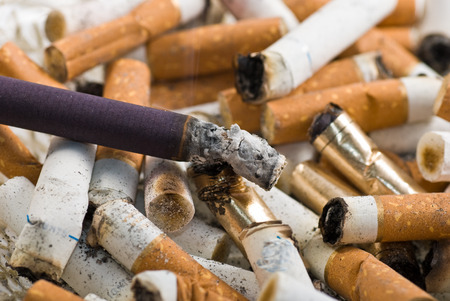 Burning cigarette in the ashtray, unhealthy life