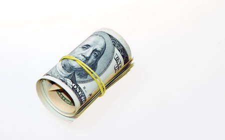 Dollar roll tightened with band. Rolled money on whiteの写真素材