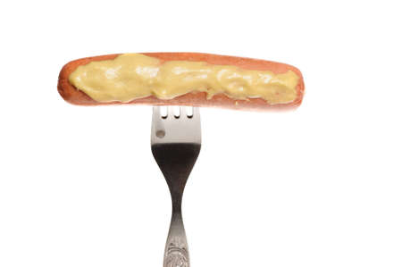 Fresh cooked sausage with mustard on a forkの写真素材
