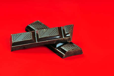 Chocolate pieces on red backgroundの写真素材