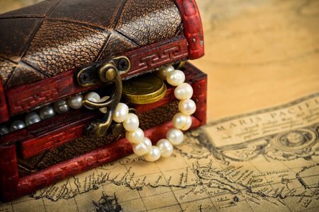 Treasure chest with coins on old adventure mapsの写真素材