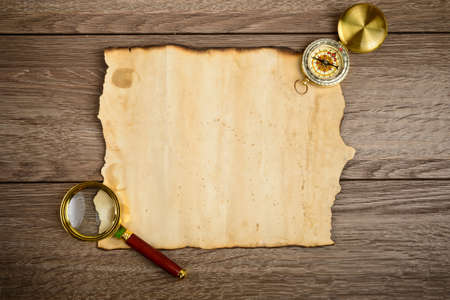 Old grunge blank paper sheet with compass and glassの写真素材