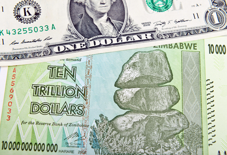 Zimbabwe ten trillon dollars bill and one American dollar. Inflation conceptの写真素材