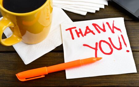 Thank you - motivational handwriting on a napkin with a cup of coffee and phoneの写真素材