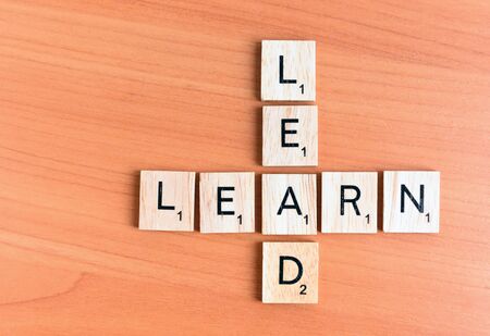 Learn and Lead text on a wooden backgroundの写真素材