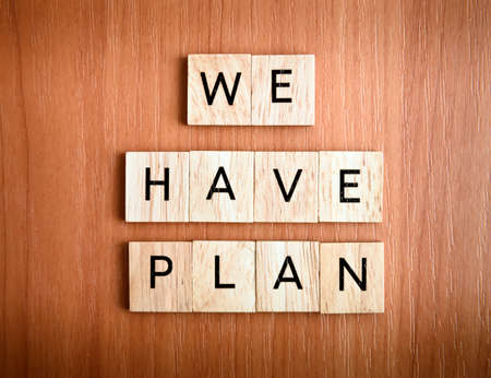 We have Plan text on tiles over wooden backgroundの写真素材