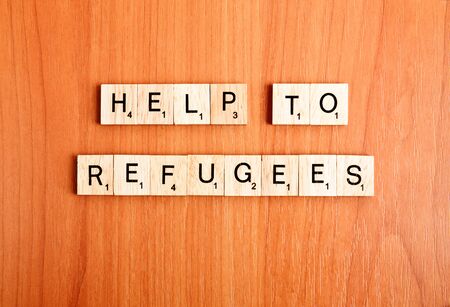 Refugees help text on wooden tiles lettersの写真素材