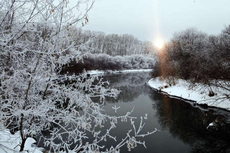 Winter landscape with white frost on trees near riverの写真素材