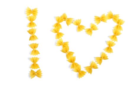 pasta farfalle arranged heart shape isolated on white
