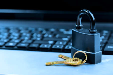 Lock on laptop keyboard with shallow depth of field toned in blueの写真素材