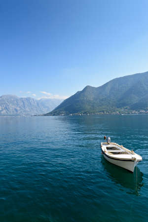 Single boat at smooth sea surface near Perast, Kotor Bay, Montenegroの写真素材