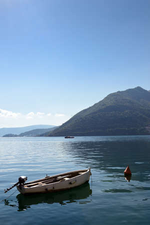 Small  boat on moorage at smooth sea surface near Perast, Kotor Bay, Montenegroの写真素材