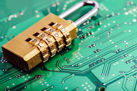Lock on the background of the computer motherboard, the concept of cyber securityの写真素材