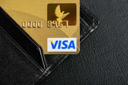 Moscow, Russia - August 05, 2017: Gold Visa credit cards in wallet close up