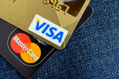 Moscow, Russia - August 05, 2017: Visa and Mastercard credit cards over blue jeansのeditorial素材